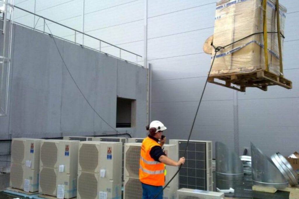 Technicien installant un système de climatisation dans un bâtiment professionnel