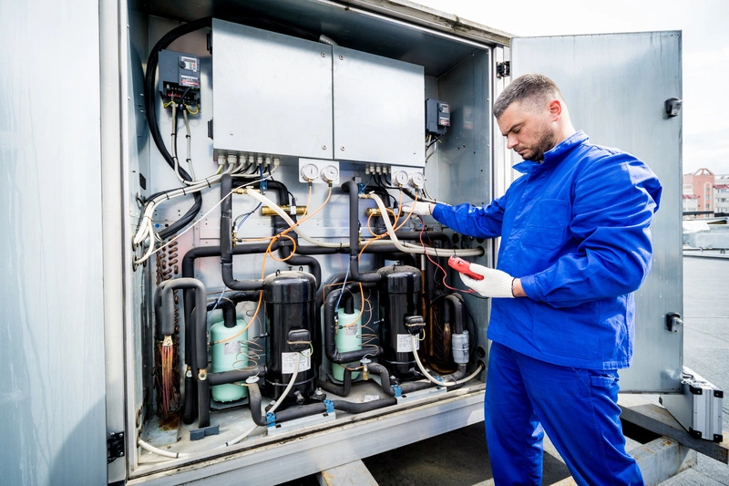 Technicien effectuant une vérification sur une unité frigorifique pour maintenance et contrôle de température